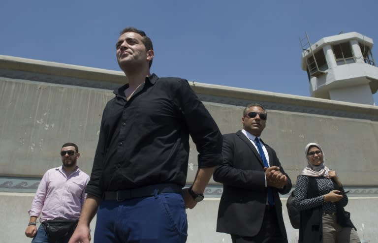 Al-Jazeera journalists, Canadian Mohamed Fahmy (C-R) and Egyptian Baher Mohamed (C-L), wait outside Cairo's Torah prison where their trial has been taking place, on July 30, 2015