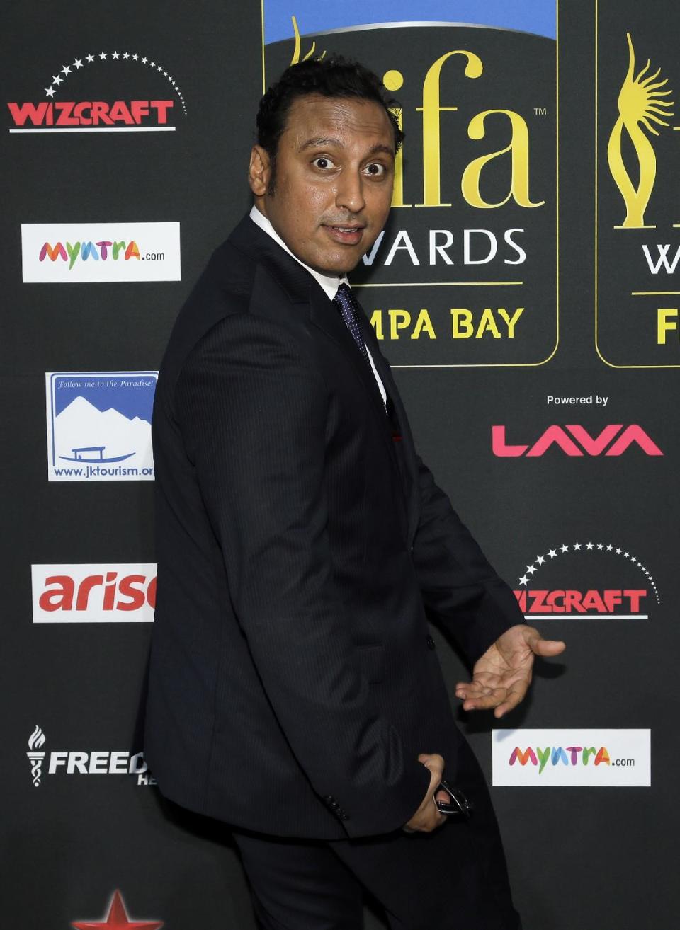 Actor Aasif Mandvi clowns for photographers as he walks the green carpet for 15th annual International Indian Film Awards Saturday, April 26, 2014, in Tampa, Fla. (AP Photo/Chris O'Meara)