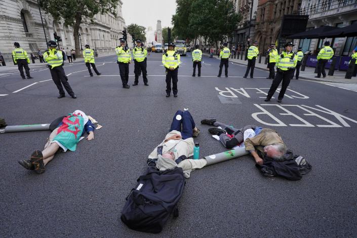 Demonstrators from Extinction Rebellion lay on the floor in Whitehall, London (PA)