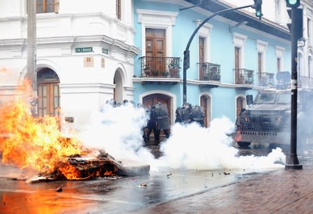 Riot police clash with demonstrators during a protest after Ecuadorian President Lenin Moreno's government ended four-decade-old fuel subsidies, in Quito