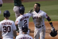 Houston Astros' Carlos Correa, right, celebrates after hitting a three-run home run that scored Kyle Tucker (30) and Alex Bregman (2) during the fourth inning of Game 4 of a baseball American League Division Series against the Oakland Athletics in Los Angeles, Thursday, Oct. 8, 2020. (AP Photo/Ashley Landis)