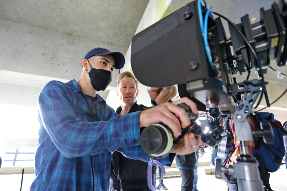 Camera first assistant, Zach Schultz, left, and cinematographer, Crille Forsberg, review the footage they just shot on the fourth level of the New Bedford parking garage for the movie "Finestkind" in this photo from April 14, 2022.