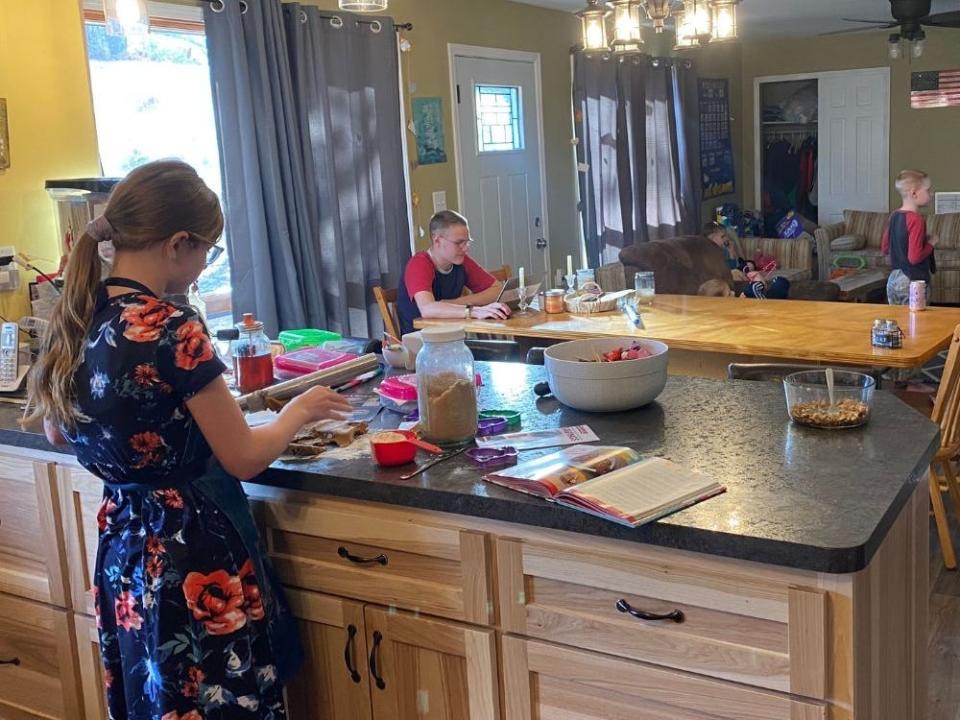 lisa's kids standing in the kitchen and dining room of their house