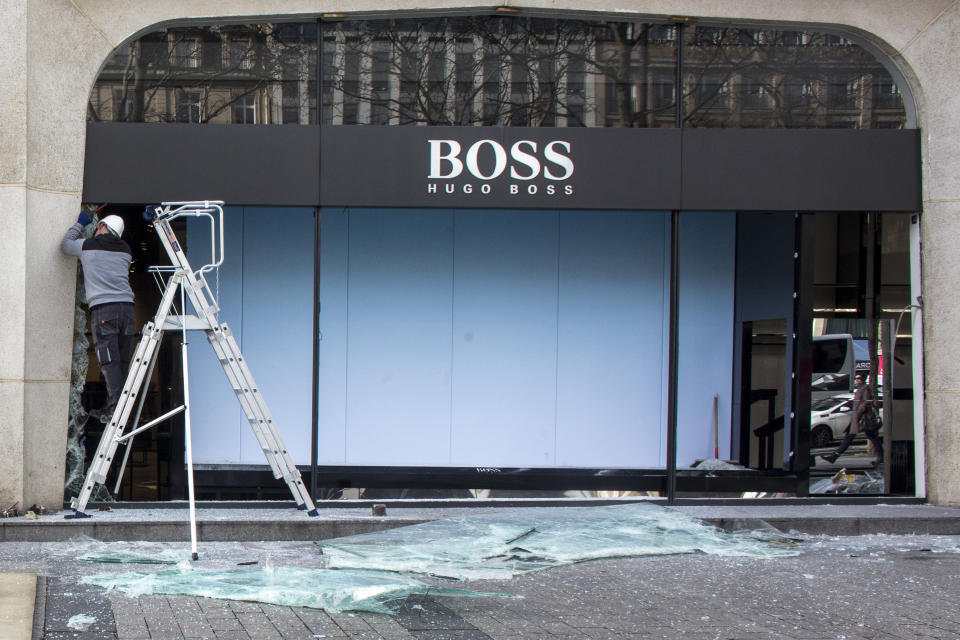 A worker repairs the shop windows of a clothing store on the Champs Elysees the day after it was vandalized during the 18th straight weekend of demonstrations by the yellow vests, in Paris, France, Sunday, March 17, 2019. Paris cleaned up one of the world's most glamorous avenues Saturday after resurgent rioting by yellow vest protesters angry at President Emmanuel Macron stunned the nation. (AP Photo/Rafael Yaghobzadeh)