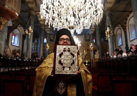 An Orthodox priest holds a Bible at St. George's Cathedral, the seat of the Ecumenical Patriarchate, ahead of a ceremony marking the new Ukrainian Orthodox church's independence, in Istanbul, Turkey January 5, 2019. REUTERS/Murad Sezer