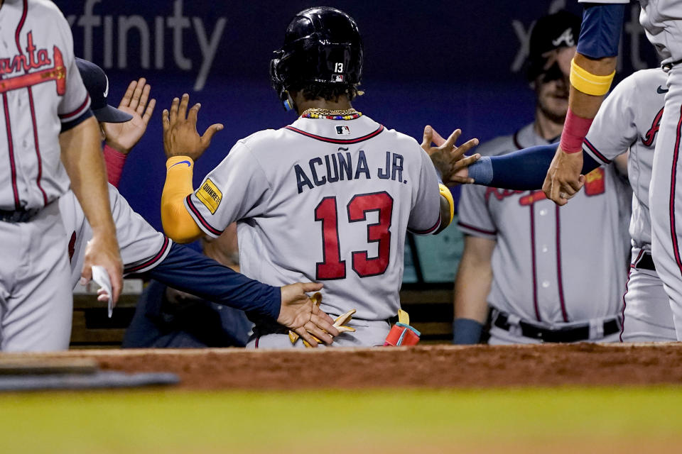 Atlanta Braves' Ronald Acuña Jr. is congratulated after scoring against the Washington Nationals during the third inning of a baseball game at Nationals Park, Thursday, Sept. 21, 2023, in Washington. (AP Photo/Andrew Harnik)
