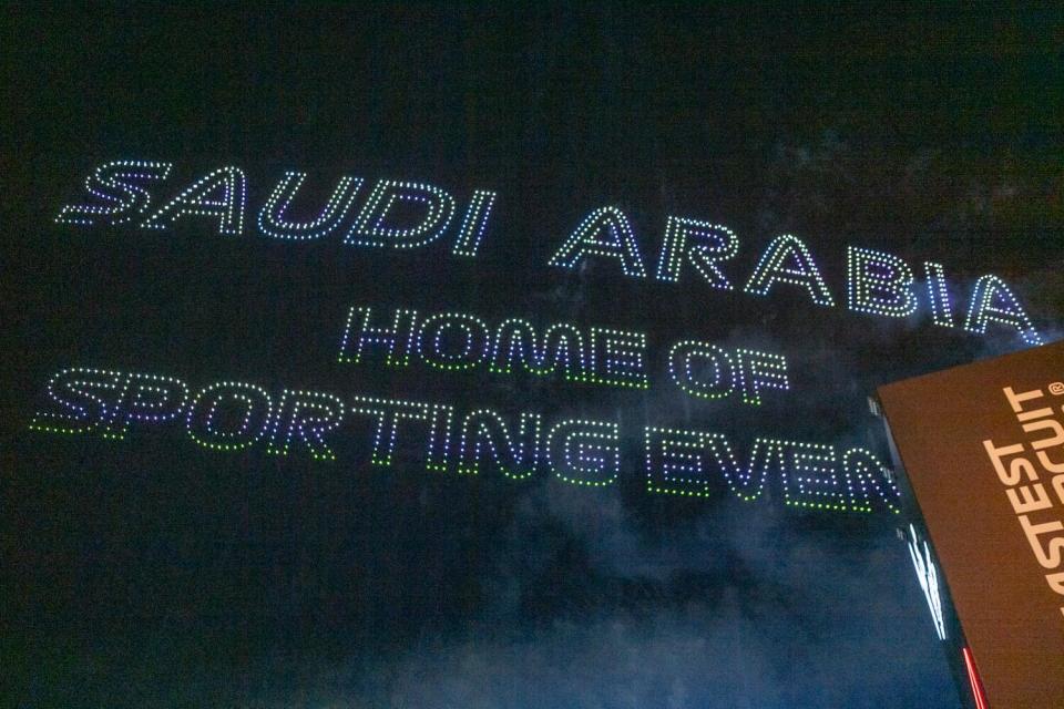 A light show in the sky spells out "Saudi Arabia: Home of sporting events."