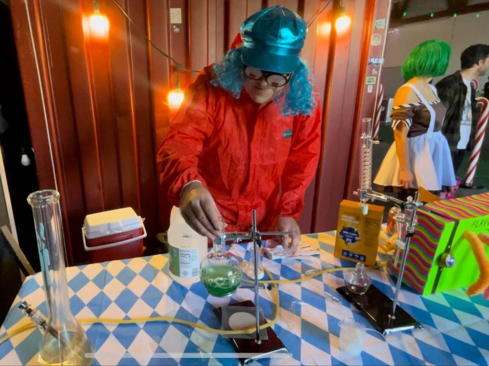 The head Oompa Loompa creates a concoction with lab tools and a bong at the Willy Wonka Experience in Downtown Los Angeles, California on 28 April. (Olivia Hebert)