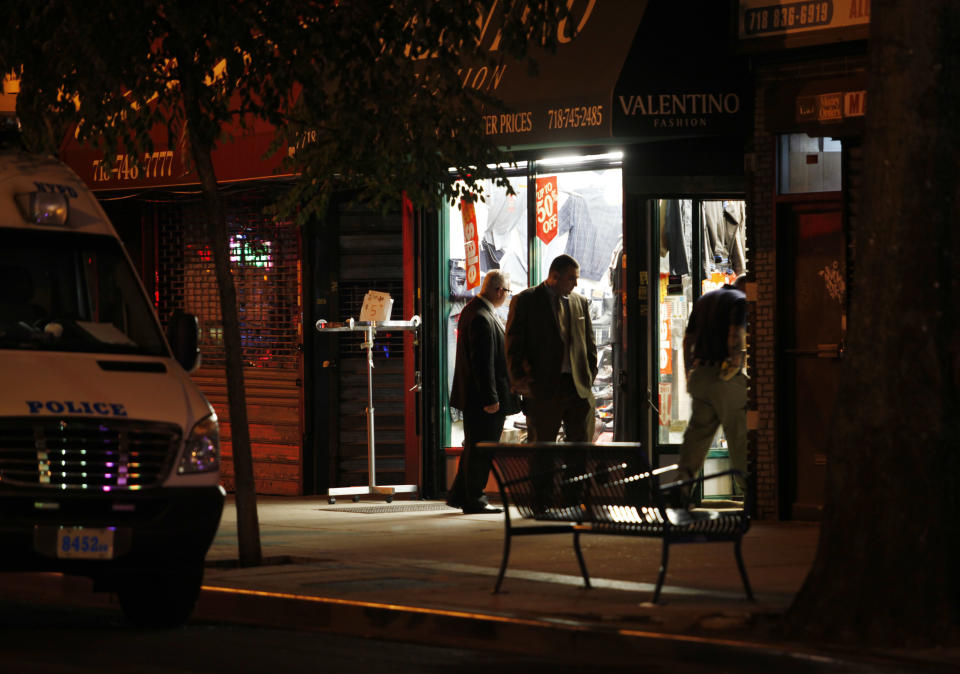 In this early Saturday, July 7, 2012 photo, authorities investigate the crime scene where clothing store owner Mohamed Gebeli was killed inside Valentino Fashion in the Bay Ridge neighborhood in the Brooklyn borough of New York. The same gun that killed Gebeli was also used in the murders of two other shopkeepers, according to police, with the latest victim being fatally shot Friday, Nov. 16, 2012, in Brooklyn's Flatbush neighborhood. (AP Photo/David Boe)