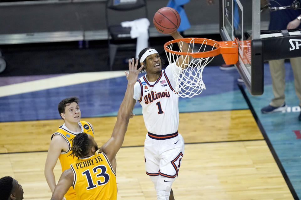 Illinois 's Trent Frazier (1) scores past Drexel's Tim Perry Jr. (13) in the first round of the NCAA tournament .(AP Photo/Charles Rex Arbogast)