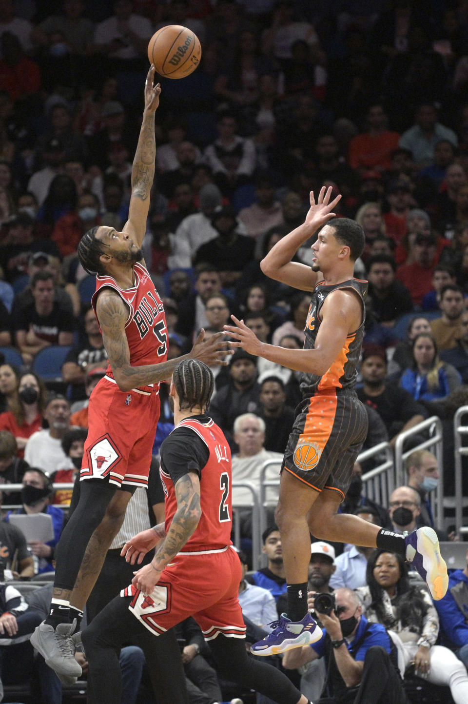 Chicago Bulls forward Derrick Jones Jr. (5) blocks a shot by Orlando Magic guard Jalen Suggs, right, during the first half of an NBA basketball game, Friday, Nov. 26, 2021, in Orlando, Fla. (AP Photo/Phelan M. Ebenhack)