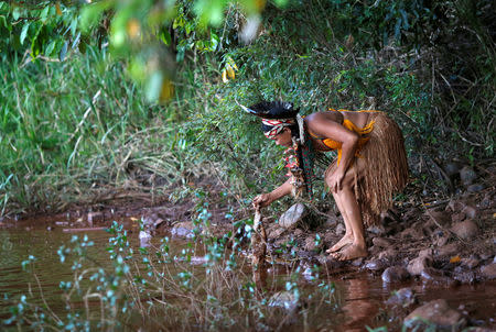 An Indigenous woman from the Pataxo Ha-ha-hae tribe holds up a dead fish near Paraopeba river, after a tailings dam owned by Brazilian mining company Vale SA collapsed, in Sao Joaquim de Bicas near Brumadinho, Brazil January 28, 2019. REUTERS/Adriano Machado