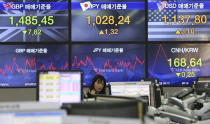 A currency trader gestures at the foreign exchange dealing room of the KEB Hana Bank headquarters in Seoul, South Korea, Friday, March 29, 2019. Asian markets were mostly higher on Friday as U.S. and Chinese officials kicked off a fresh round of trade talks in Beijing. (AP Photo/Ahn Young-joon)
