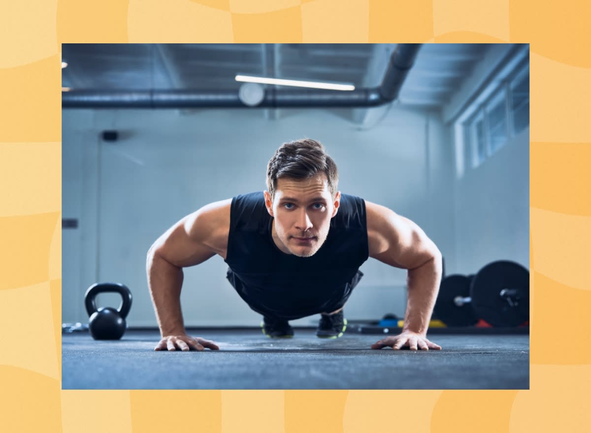 man doing pushups in a dark gym