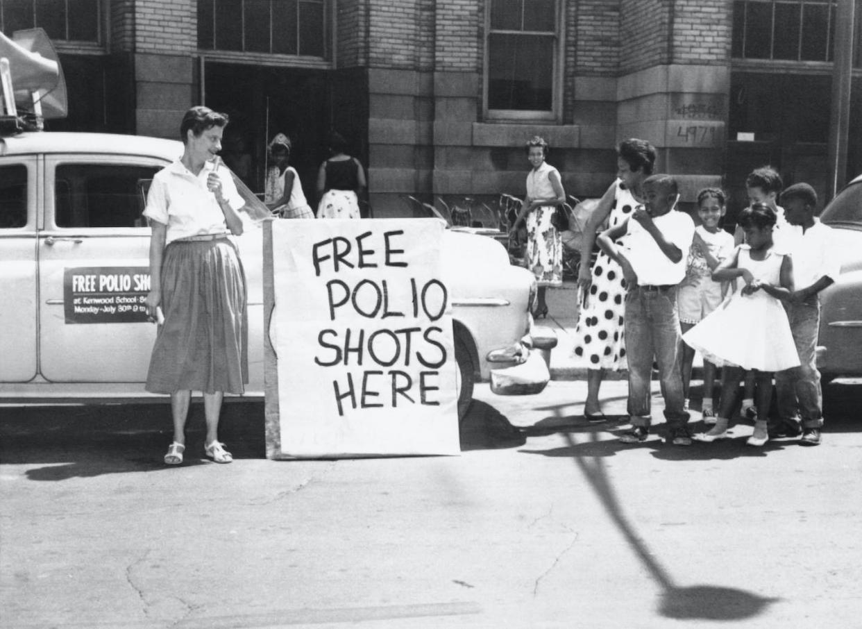 In 1956, during the height of the polio epidemic in the U.S., health officials in Chicago offer polio shots at a public school. <a href="https://www.gettyimages.com/detail/news-photo/free-chicago-illinois-mrs-rose-stamler-uses-microphone-to-news-photo/514975204?adppopup=true" rel="nofollow noopener" target="_blank" data-ylk="slk:Bettmann via Getty Images;elm:context_link;itc:0;sec:content-canvas" class="link ">Bettmann via Getty Images</a>