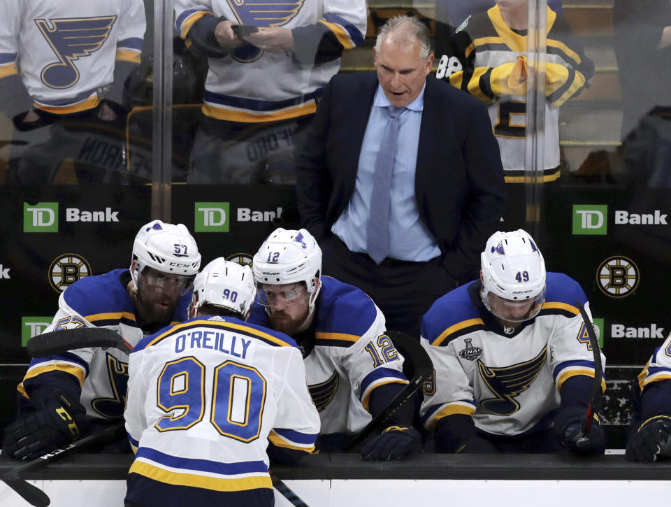 St. Louis Blues head coach Craig Berube, right, watches as Ryan O'Reilly (90) speaks to teammates on the bench during the second period in Game 7 of the NHL hockey Stanley Cup Final against the Boston Bruins, Wednesday, June 12, 2019, in Boston. (AP Photo/Charles Krupa)