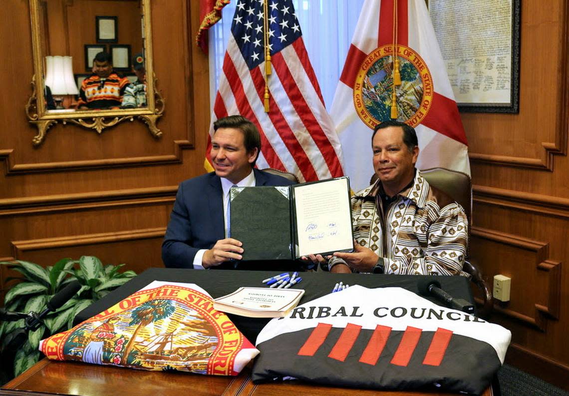 El gobernador Ron DeSantis y Marcellus Osceola Jr., presidente de la tribu seminole, muestran el pacto de juegos de azar que firmaron en abril.