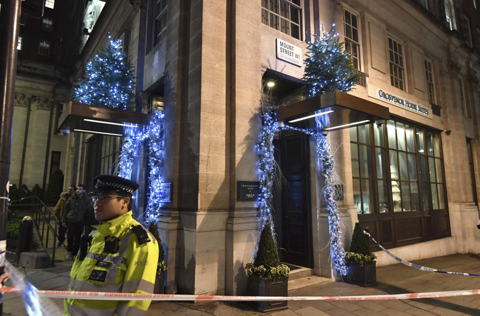 Police secure the area outside the Grosvenor House Suites in Park Lane, central London, early Tuesday Jan. 1, 2019, after a security guard was stabbed to death and three others injured as they tried to stop a group of men from entering a New Year's Eve party. Emergency services were called to the property on Park Lane around 05.30 Tuesday following reports of violence. (John Stillwell/PA via AP)