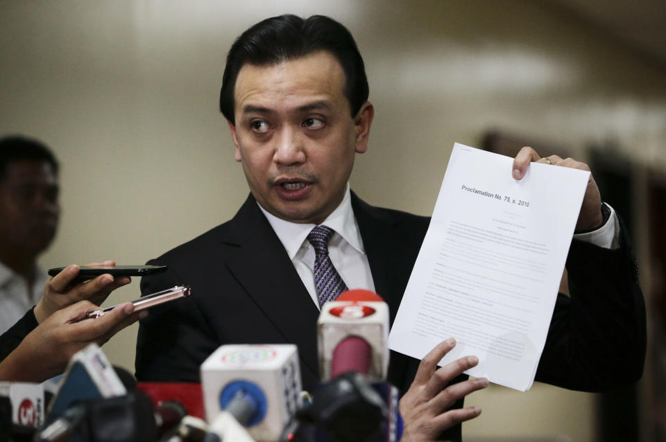 Philippine opposition Sen. Antonio Trillanes IV shows to reporters a copy of his amnesty documents outside his office where he remains holed up in the Philippine Senate in suburban Pasay city, south of Manila, Philippines on Tuesday, Sept. 11, 2018. Trillanes has been staying inside his senate office for over a week to avoid an arrest order by Philippine President Rodrigo Duterte. (AP Photo/Aaron Favila)