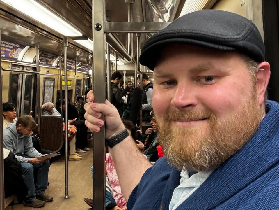 a man takes a selfie on the NYC subway