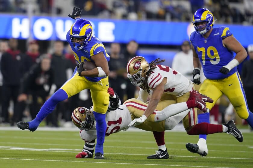 Los Angeles Rams' Kendall Blanton, left, is stopped by San Francisco 49ers' Azeez Al-Shaair, bottom, during the second half of the NFC Championship NFL football game Sunday, Jan. 30, 2022, in Inglewood, Calif. (AP Photo/Marcio Jose Sanchez)