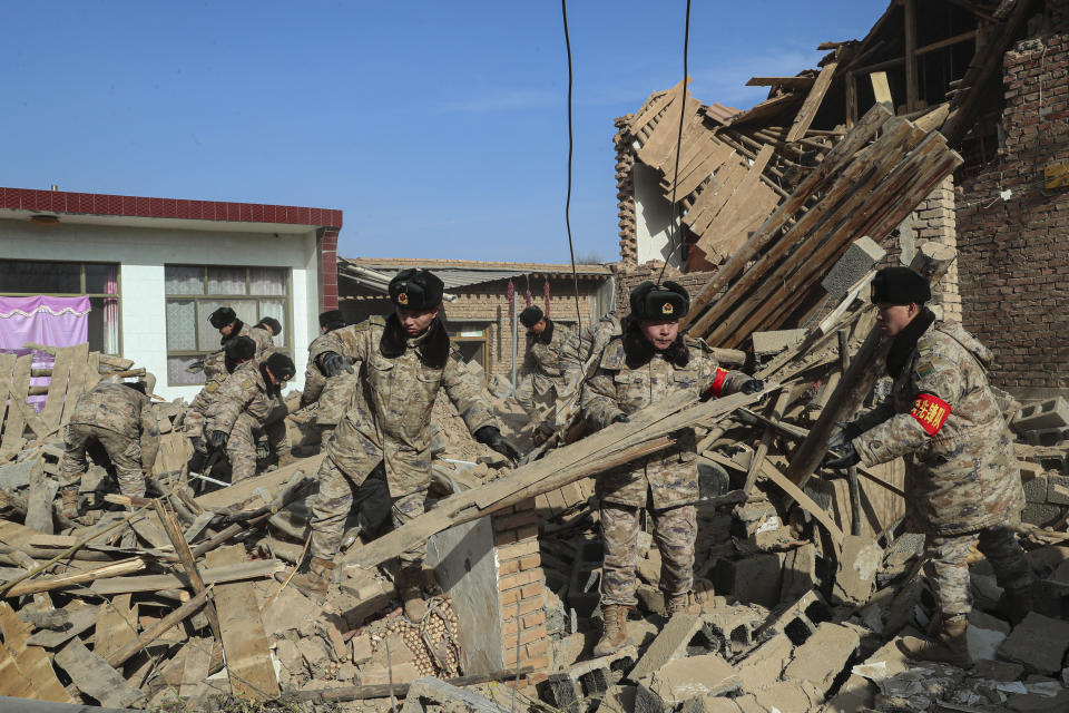 In this photo released by Xinhua News Agency, soldiers clear debris on the damaged houses after the earthquake in Chenjia Village of Dahejia Township, Jishishan County, northwest China's Gansu Province on Dec. 20, 2023. The strong earthquake that hit northwest China this week, and killed at least 148 people, has caused tens of millions of estimated economic losses in the agricultural and fisheries industries, state media reported Saturday, Dec. 23, 2023. (Feng Yanrong/Xinhua via AP)