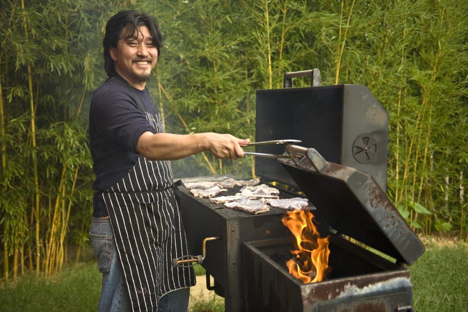In this June 2012 publicity photo provided by Artisan Books, Chef Edward Lee grills lamb in Louisville, K.Y. Lee recommends lamb barbecue for its smokiness and simplicity in his book, "Smoke & Pickles," published by Artisan Books. AP Photo/Artisan Books, Grant Cornett)
