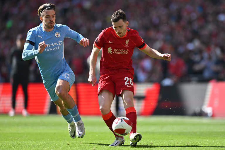 Jack Grealish y Andrew Robertson en un encuentro entre Manchester City y Liverpool; serían titulares este jueves