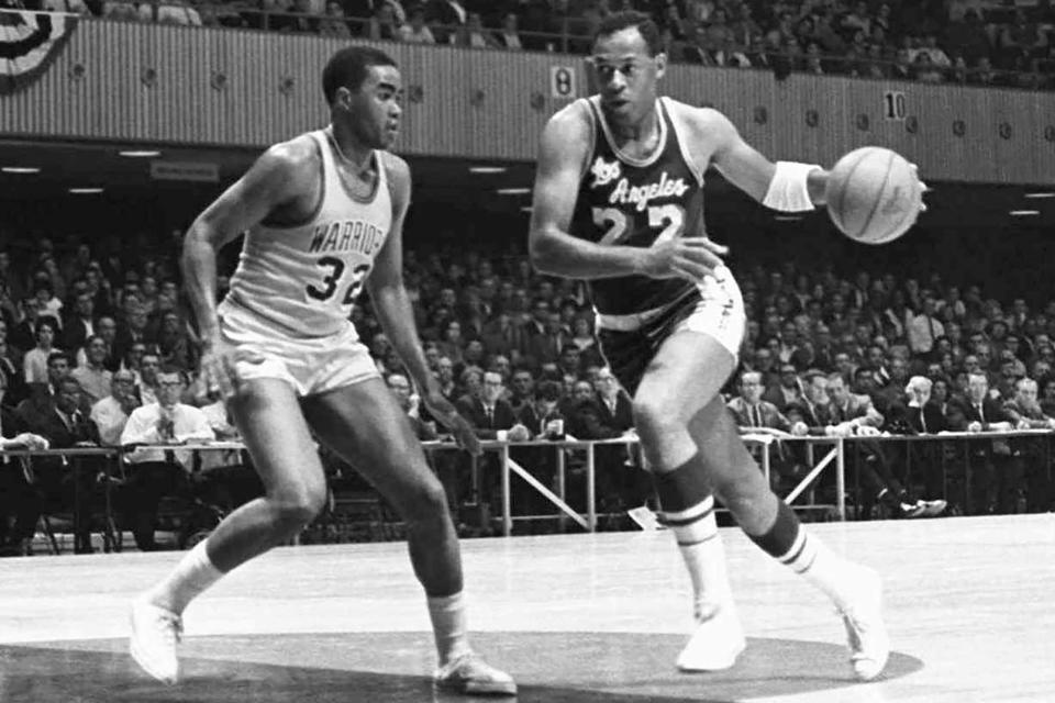 Elgin Baylor of the Los Angeles Lakers makes a fast break past the Golden State Warriors' McCoy McLemore (32) in San Francisco in October 1965.