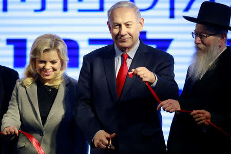 Israeli Prime Minister Benjamin Netanyahu and his wife Sara cut a ribbon during an inauguration ceremony for a fortified emergency room at the Barzilai Medical Center in Ashkelon, southern Israel, February 20, 2018. REUTERS/Amir Cohen