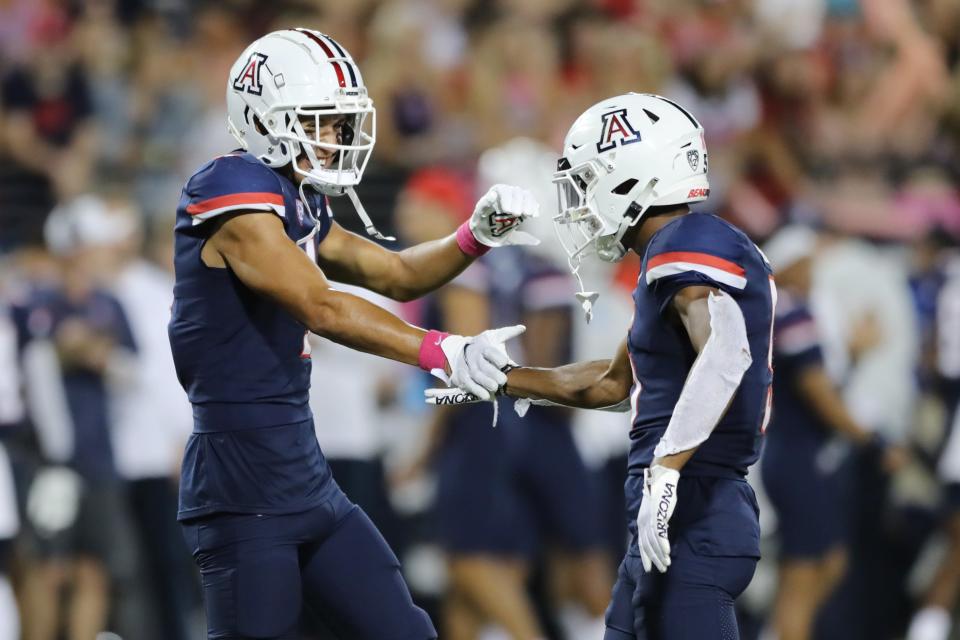 Wide receiver Tetairoa McMillan #4 of the Arizona Wildcats and wide receiver Dorian Singer #5 of the Arizona Wildcats celebrate together during the first half of the NCAA football game against the Colorado Buffaloes at Arizona Stadium on Oct. 1, 2022, in Tucson, Arizona.