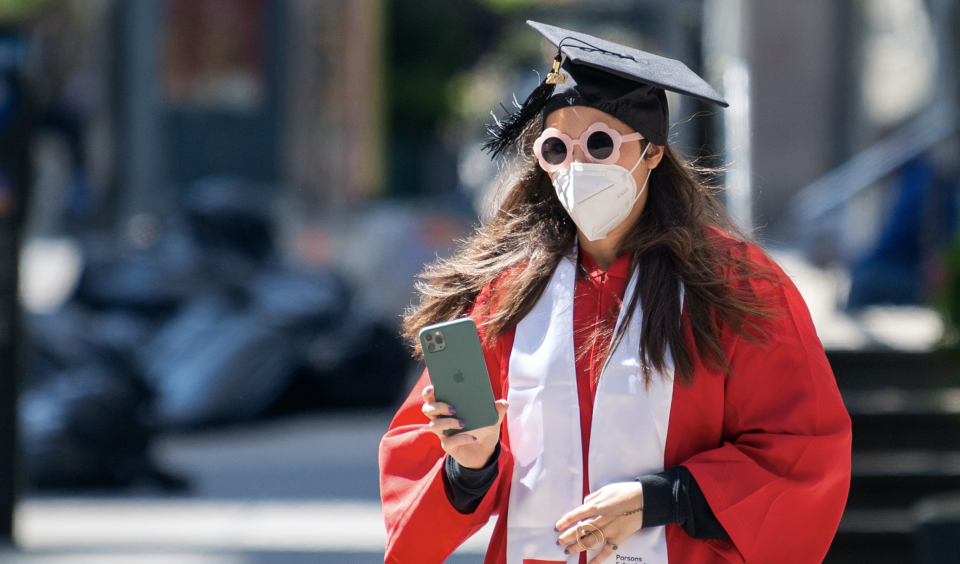 A graduate wearing a mask, cap and gown amid the coronavirus pandemic on May 14, 2020 in New York City. Photo: Alexi Rosenfeld/Getty Images)