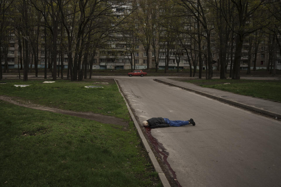 FILE - The body of a man killed during a Russian bombardment lies on a street in a residential neighborhood in Kharkiv, Ukraine, Tuesday, April 19, 2022. (AP Photo/Felipe Dana, File)