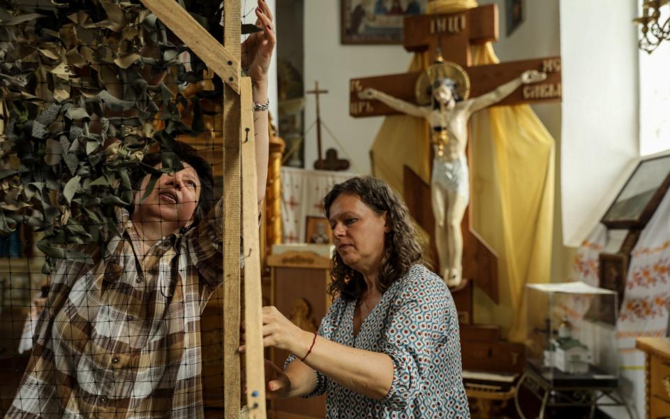 People weave a camouflage net at Saint Nicholas Church in Poltava, Ukraine