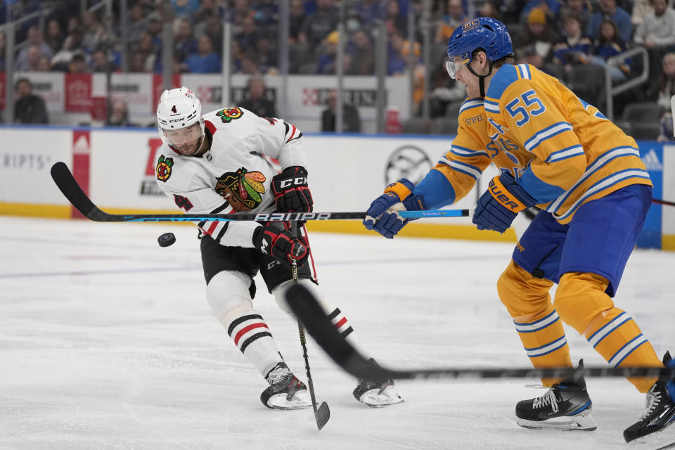Chicago Blackhawks' Seth Jones (4) and St. Louis Blues' Colton Parayko (55) battle for a loose puck during the third period of an NHL hockey game Thursday, Dec. 29, 2022, in St. Louis. (AP Photo/Jeff Roberson)