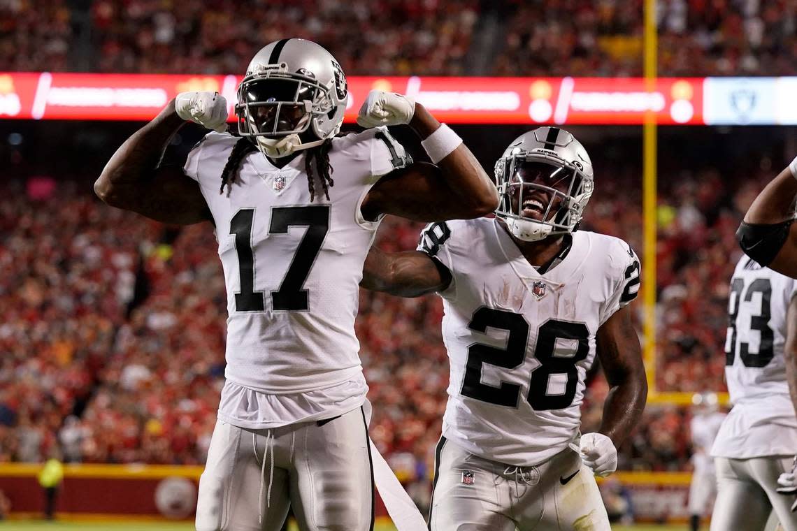 Las Vegas Raiders wide receiver Davante Adams (17) is congratulated by Josh Jacobs (28) after scoring during the first half of an NFL football game against the Kansas City Chiefs Monday, Oct. 10, 2022, in Kansas City, Mo.