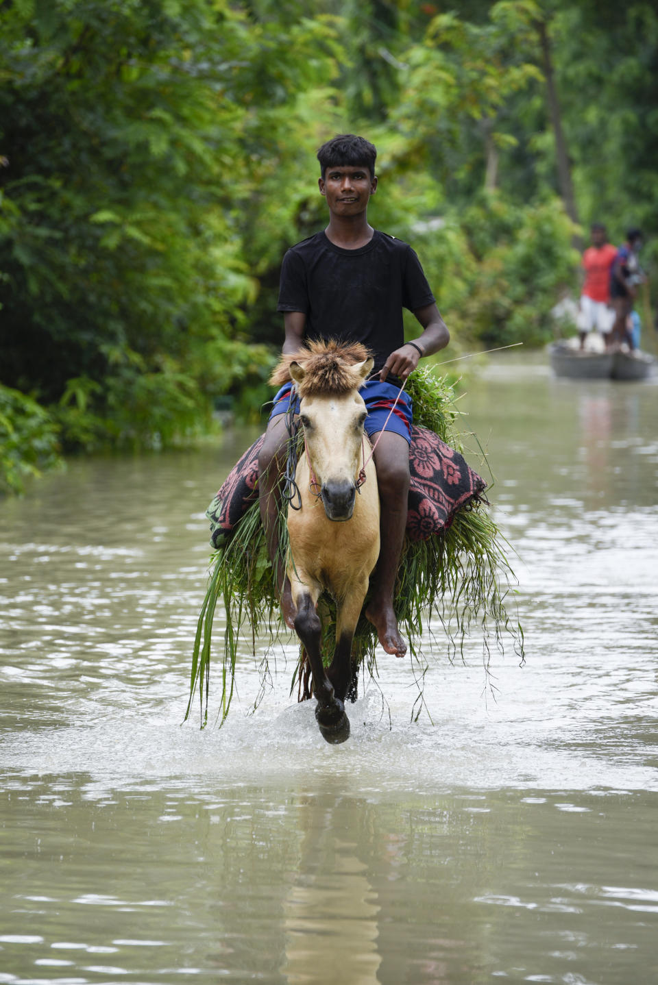 A boy rides a donkey as he id croosing a flooded street in a village in Kamrup district of Assam, in India on 14 July 2020. (Photo by David Talukdar/NurPhoto via Getty Images)