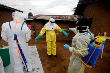 Healthcare worker Kavota Mugisha Robert decontaminates his colleague after he entered the house of 85-year-old woman suspected of dying of Ebola in the eastern Congolese town of Beni