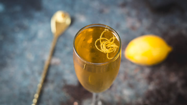 Overhead view of cocktail glass with spoon and lemon