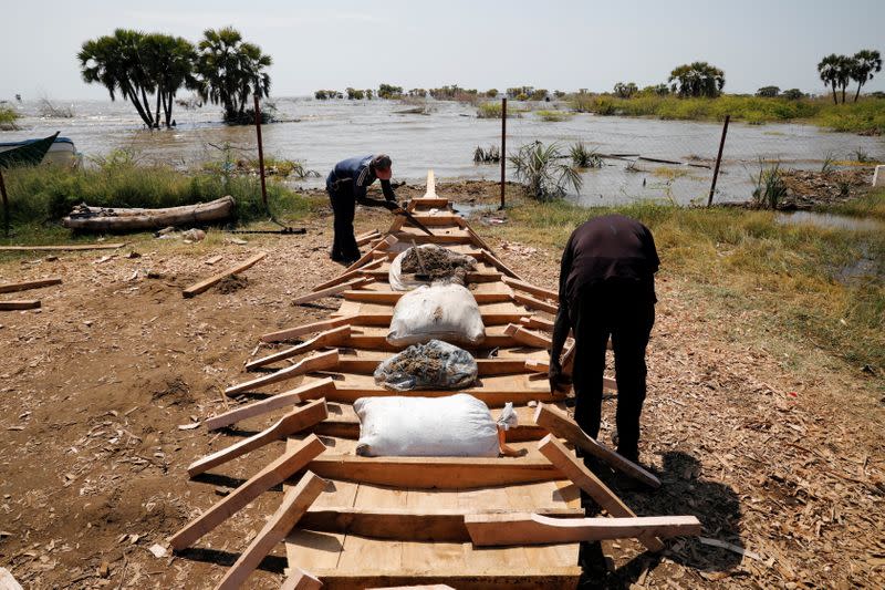 Men construct a fishing boat on a beach at Lake Turkana, near the town of Kalokol, Turkana county