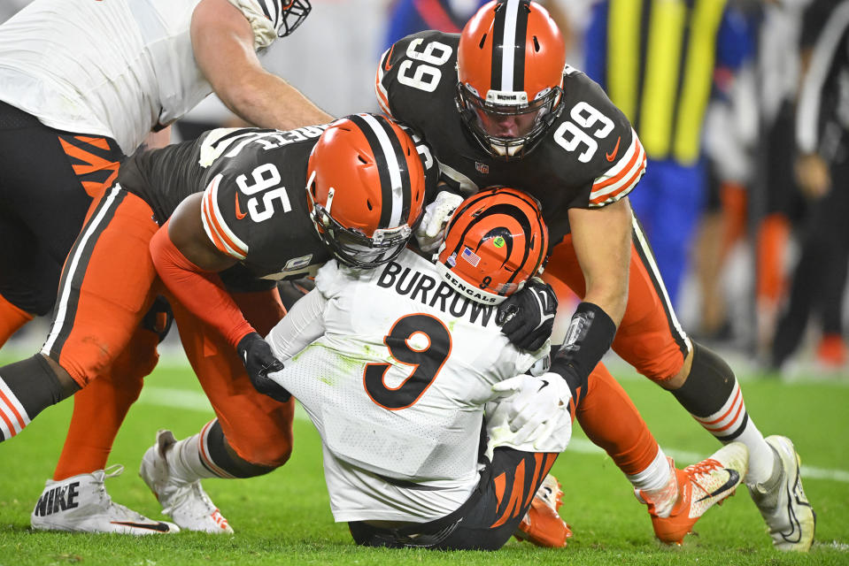 Cincinnati Bengals quarterback Joe Burrow (9) is sacked by Cleveland Browns defensive end Myles Garrett (95) and Taven Bryan (99) during the second half of an NFL football game in Cleveland, Monday, Oct. 31, 2022. (AP Photo/David Richard)