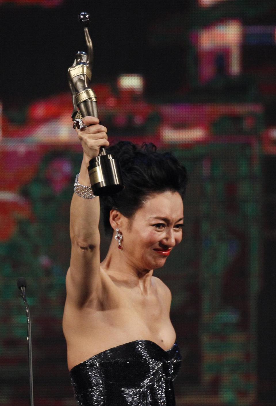 Hong Kong actress Kara Wai Ying Hung raises the trophy after winning the Best Supporting Actress for her role in the movie " Rigor Mortis " at the 33rd Hong Kong Film Awards in Hong Kong, Sunday, April 13, 2014. (AP Photo/Vincent Yu)