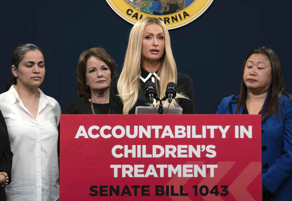 Hotel heiress and media personalty Paris Hilton, center, discusses a proposed bill calling on more transparency for youth treatment facilities during a news conference in Sacramento, Calif., Monday, April 15, 2024. (AP Photo/Rich Pedroncelli)