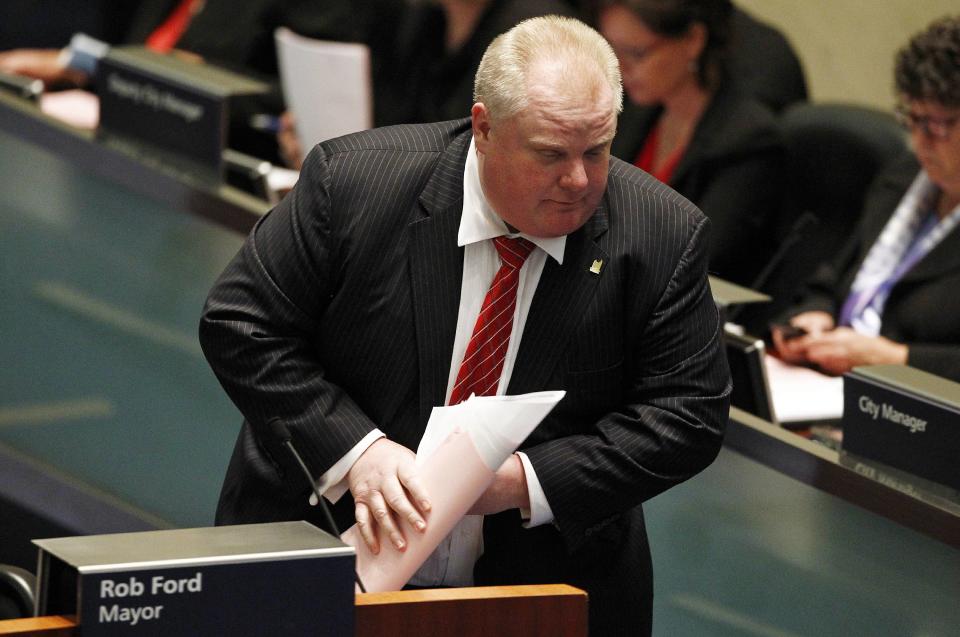 Toronto Mayor Rob Ford clears papers off his desk following a vote at City Hall in Toronto November 18, 2013. Toronto's City Council voted overwhelmingly on Monday to limit further the powers of embattled Toronto Mayor Rob Ford, who denounced the move as a coup d'etat and warned political foes of an election battle next year to rival the Gulf War. Ford has been under fire after admitting to smoking crack cocaine, buying illegal drugs and driving after drinking alcohol. REUTERS/Aaron Harris (CANADA - Tags: POLITICS DRUGS SOCIETY)