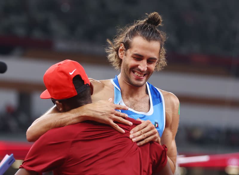 Foto del domingo del italiano Gianmarco Tamberi y el qatarí Mutaz Essa Barshim celebran tras el oro compartido en salto en alto.