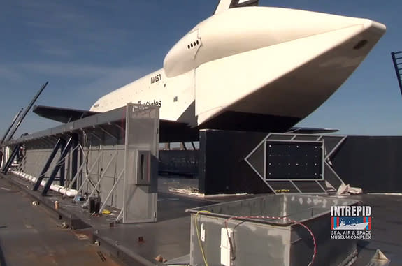 Space shuttle Enterprise, seen here with the original remnants of its Hurricane Sandy-damaged display, will be temporarily covered for the winter.