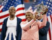 Serena Williams (R) of the US holds up the US Open Women's Singles trophy as her sister Venus looks on at the US Open Tennis Tournament 07 September, 2002 at Flushing Meadows, NY. The fourth meeting of the Williams sisters in a grand-slam final ended with Serena winning 6-4, 6-3. (Photo by Timothy A. Clary/AFP/Getty Images)