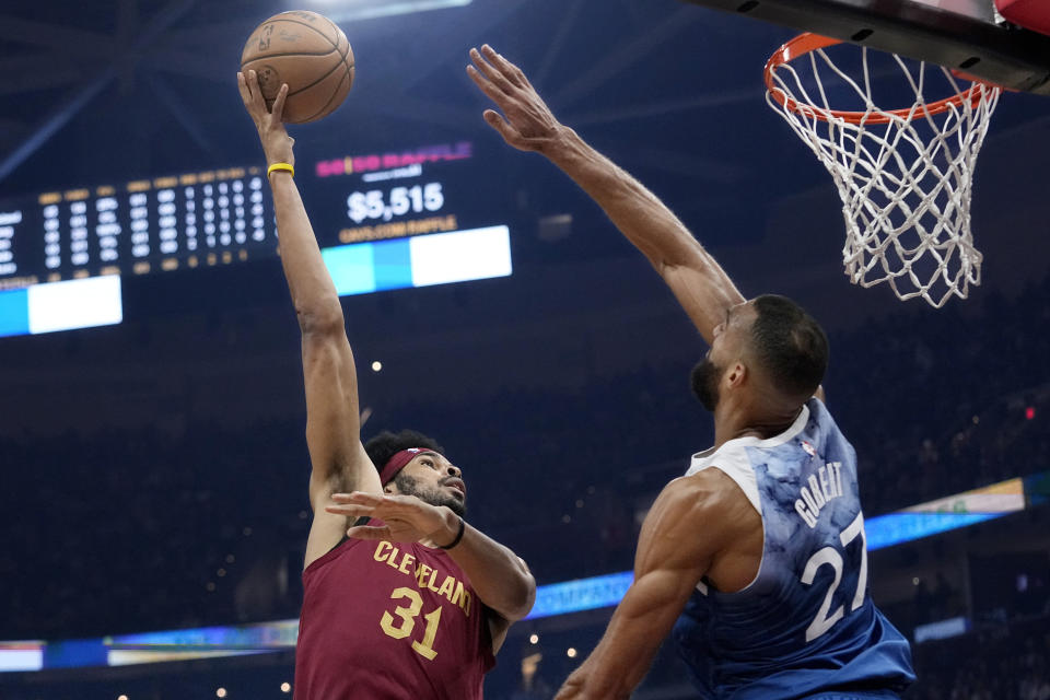 Cleveland Cavaliers center Jarrett Allen (31) shoots as Minnesota Timberwolves center Rudy Gobert (27) defends during the first half of an NBA basketball game Friday, March 8, 2024, in Cleveland. (AP Photo/Sue Ogrocki)