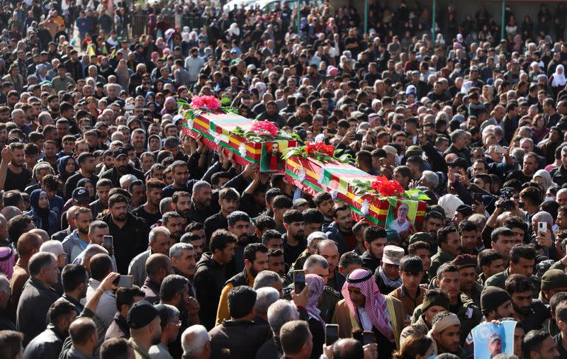 People carry coffins during a funeral in Derik countryside