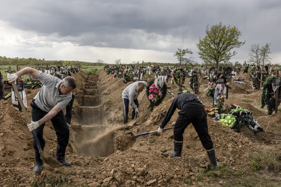 Grave diggers bury the bodies of a husband and wife who were both killed by Russian shelling that hit a supermarket in Kherson, Ukraine, May 10, 2023. (Finbarr O